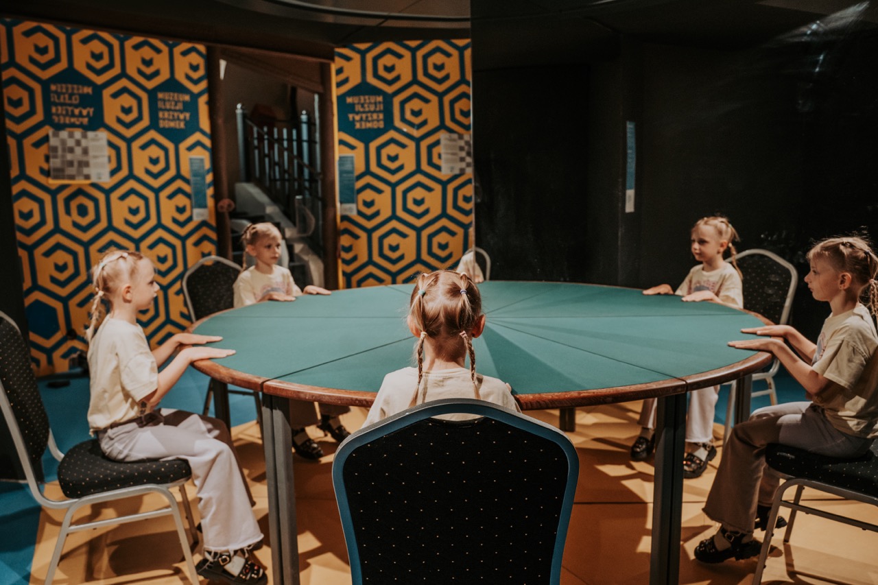 Iluzja wielokrotnego odbicia – dziecko przy stole w Muzeum Iluzji